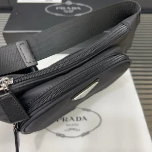Prada Nylon Waist Bag in black with zippered compartments, displayed on a branded box and paper, emphasizing designer replica fashion.