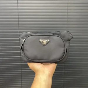 Prada Nylon Waist Bag held in hand, featuring logo and sleek design, showcasing replica handbag for e-commerce platform RepsGoat.