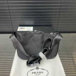Prada Nylon Waist Bag displayed on a white dust bag with Prada logo, featuring a sleek black design and adjustable strap.