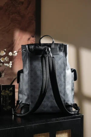 Chip Diamond Jumping Code Backpack by Louis Vuitton, showcasing a stylish design with adjustable straps and a hanging lid, set against a warm, softly lit background.