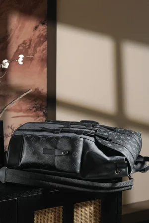 Chip Diamond Jumping Code Backpack by Louis Vuitton, stylish black design with logo pattern, showcased on a surface with soft lighting, ideal for daily use and travel.