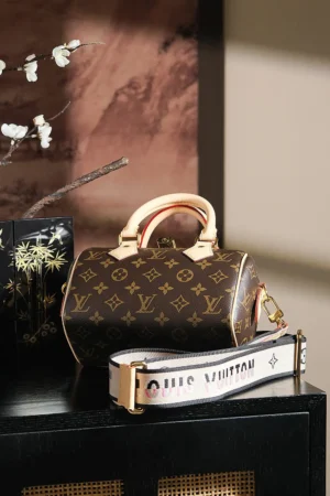 Louis Vuitton Mini Speedy 20 monogram canvas bag with beige leather handles and detachable logo strap
