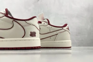 Nike Air Jordan 1 Low Undefeated Sail Team Red leather sneakers with stitched logo and detailed accents