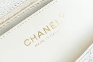 Chanel bag interior close-up showing white leather lining with gold embossed logo and made in Italy text
