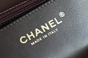 Chanel handbag close-up brown leather with gold logo made in Italy textured grain material