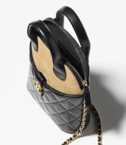 Handmade vertical shell bag in suede brown leather with black patchwork, featuring a quilted design and chain strap, showcasing luxury craftsmanship.