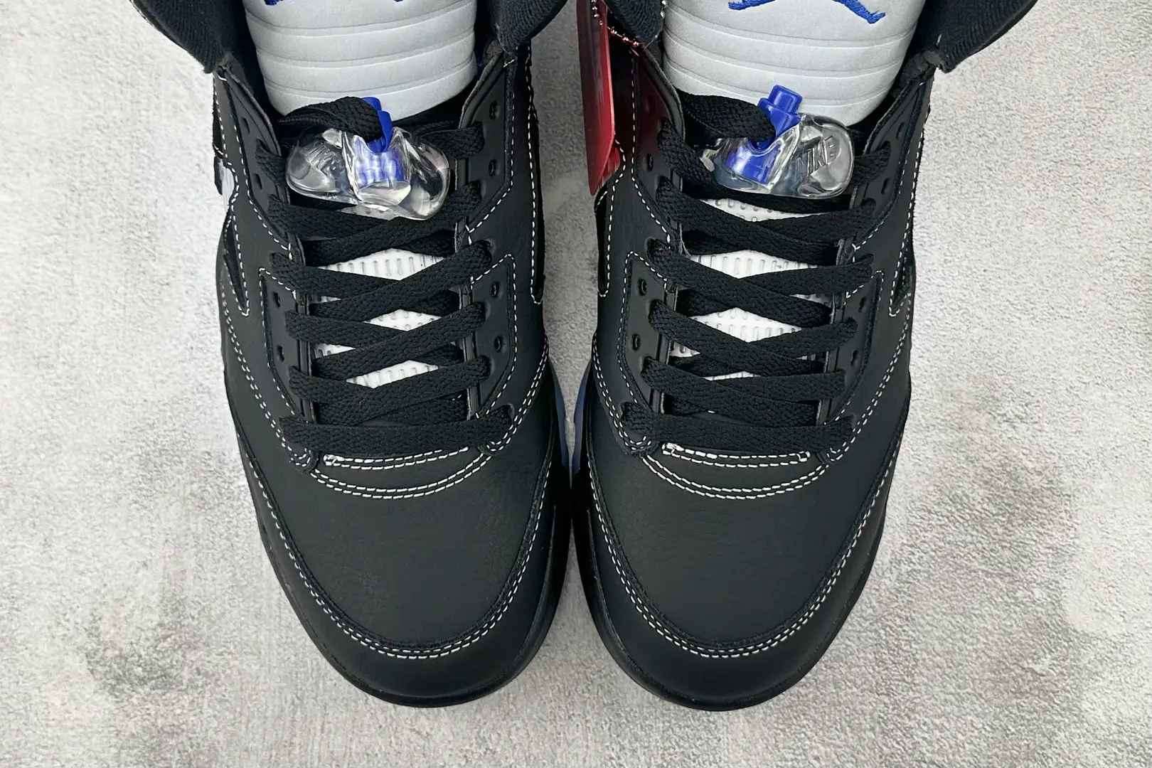 Nike Air Jordan 4 Retro black white royal blue leather sneakers with clear lace locks and black laces