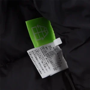 No brand, product type, or model info visible on fabric care tag against black fabric background
