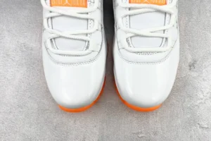 Nike Air Jordan 11 Retro 2022 white orange patent leather sneakers close-up on concrete background