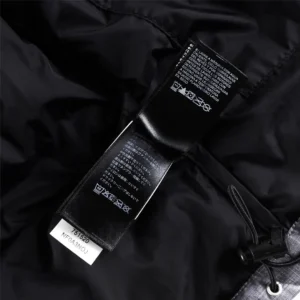 Label and care instructions tag inside The North Face children's down jacket, emphasizing quality and lightweight design for warmth and durability.