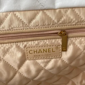 Chanel quilted bag beige satin material gold zipper pull made in Italy close-up detail