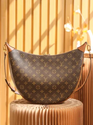 Montaigne BB Monogram canvas handbag by Louis Vuitton, featuring a crescent shape and signature LV logo, displayed against a warm, textured background.