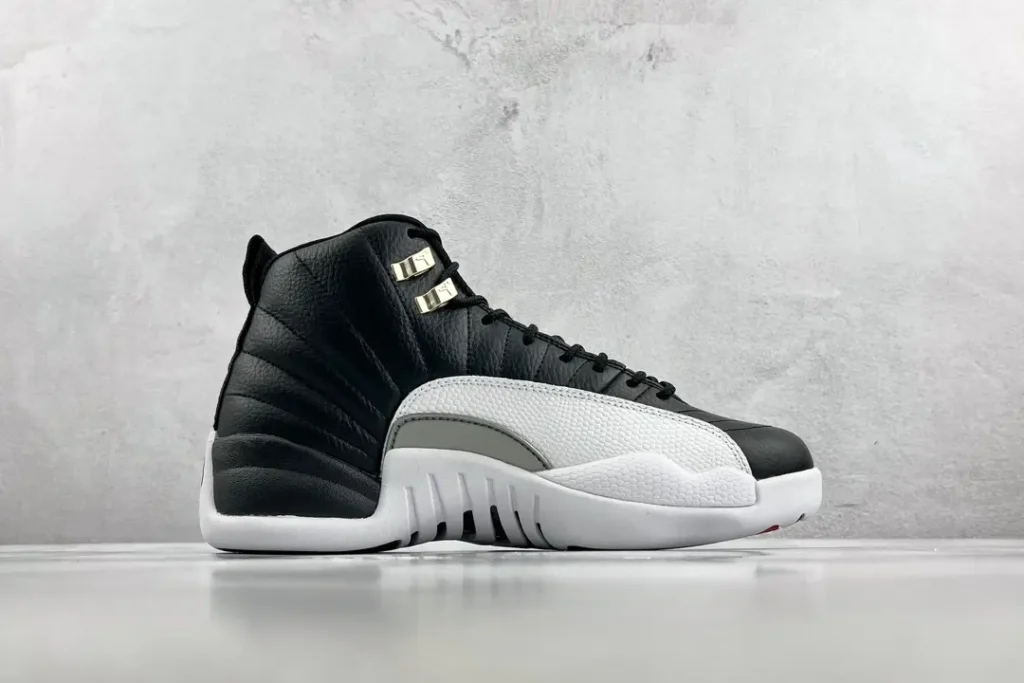 Air Jordan 12 Retro black white grey leather sneakers with metal eyelets and white sole