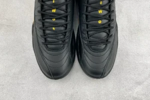 Nike Air Jordan 12 Retro Taxi black yellow leather sneakers with textured detailing and yellow lace accents