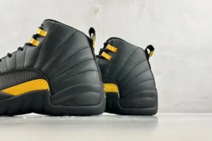 Nike Air Jordan 12 Retro black university gold leather sneakers with textured side panel and metal eyelets