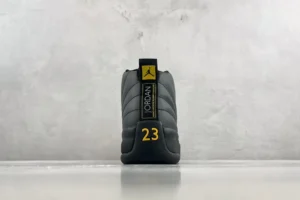 Nike Air Jordan 12 Retro black varsity maize leather sneakers with number 23 detail on heel