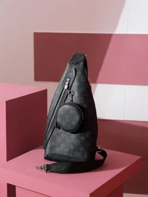 Duo Slingbag Taigarama in Monogram and Taiga leather, featuring a sleek design with a circular accessory pouch, set against a modern pink backdrop.