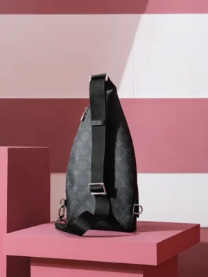 Duo Slingbag Taigarama in Monogram and Taiga leather displayed on a pink pedestal, showcasing its sleek design and adjustable strap.