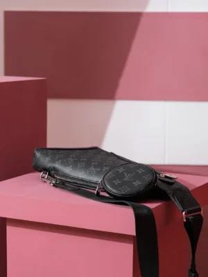 Duo Slingbag Taigarama in Monogram and Taiga leather on a pink display surface, showcasing the bag's design and details, emphasizing its luxury appeal and stylish aesthetic.