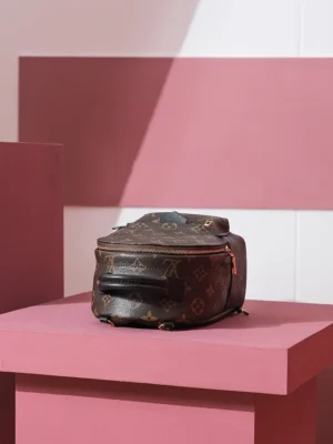 Palm Springs Mini backpack in Monogram canvas on a pink pedestal, showcasing luxury design and functionality.