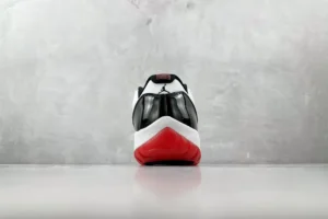 Nike Air Jordan 11 Low Concord white black red patent leather sneakers rear view on gray floor