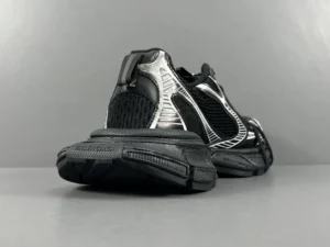 Black silver Balenciaga 3XL mesh strap shoes featuring a sleek design and textured detailing, showcasing the rear view on a gray background.