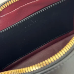 Gucci bag interior black leather lining red leather trim gold zipper detailed close-up