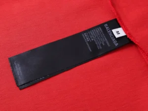 Balenciaga clothing tag black fabric size M sewn on red textile garment made in Portugal