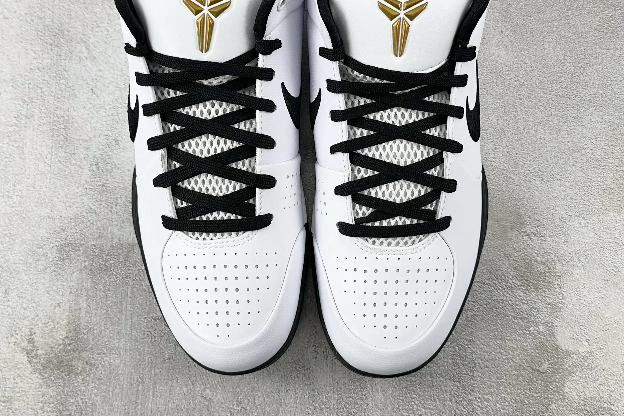 Nike Zoom Kobe 4 "Mambacita" G shoes in white and black with gold logo, featuring mesh detailing and black laces, displayed on a gray background.