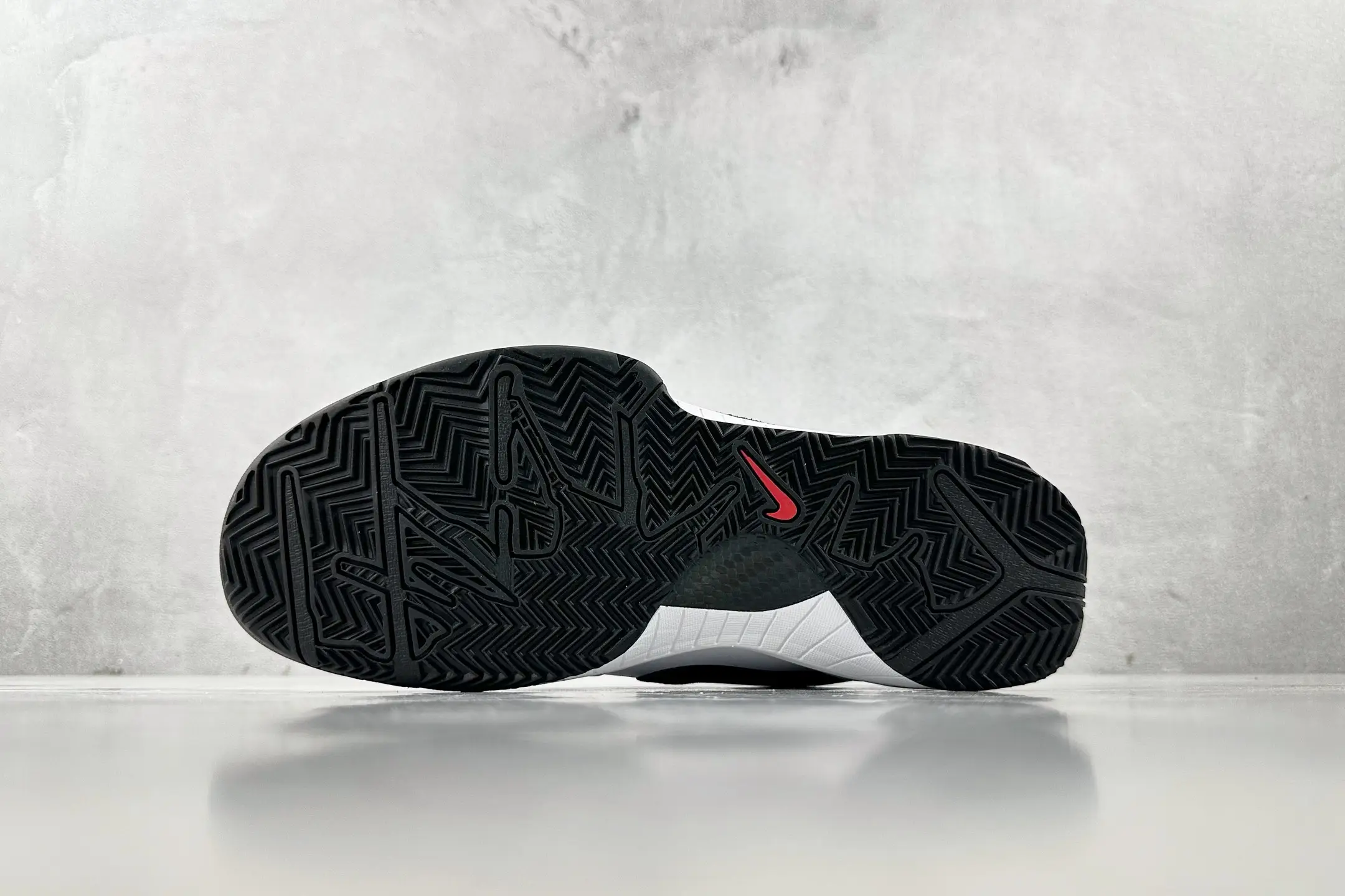 Nike Zoom Kobe 4 "Mambacita" G sneaker sole with intricate tread pattern and red Nike logo against a gray background.