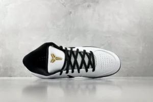 Nike Zoom Kobe 4 "Mambacita" G sneaker in white and black, featuring gold logo, displayed against a gray background.