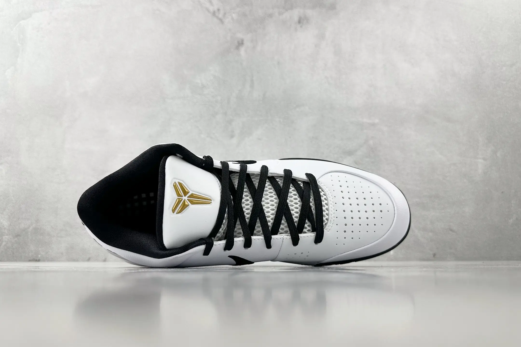 Nike Zoom Kobe 4 "Mambacita" G sneakers in white and black, featuring perforated upper and gold logo, displayed on a light surface.