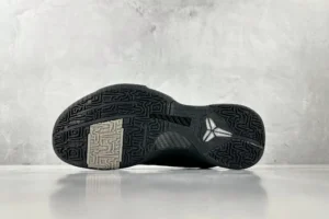 Nike Zoom Kobe 5 Black Knight sneaker sole with textured rubber and signature logo on a gray background.