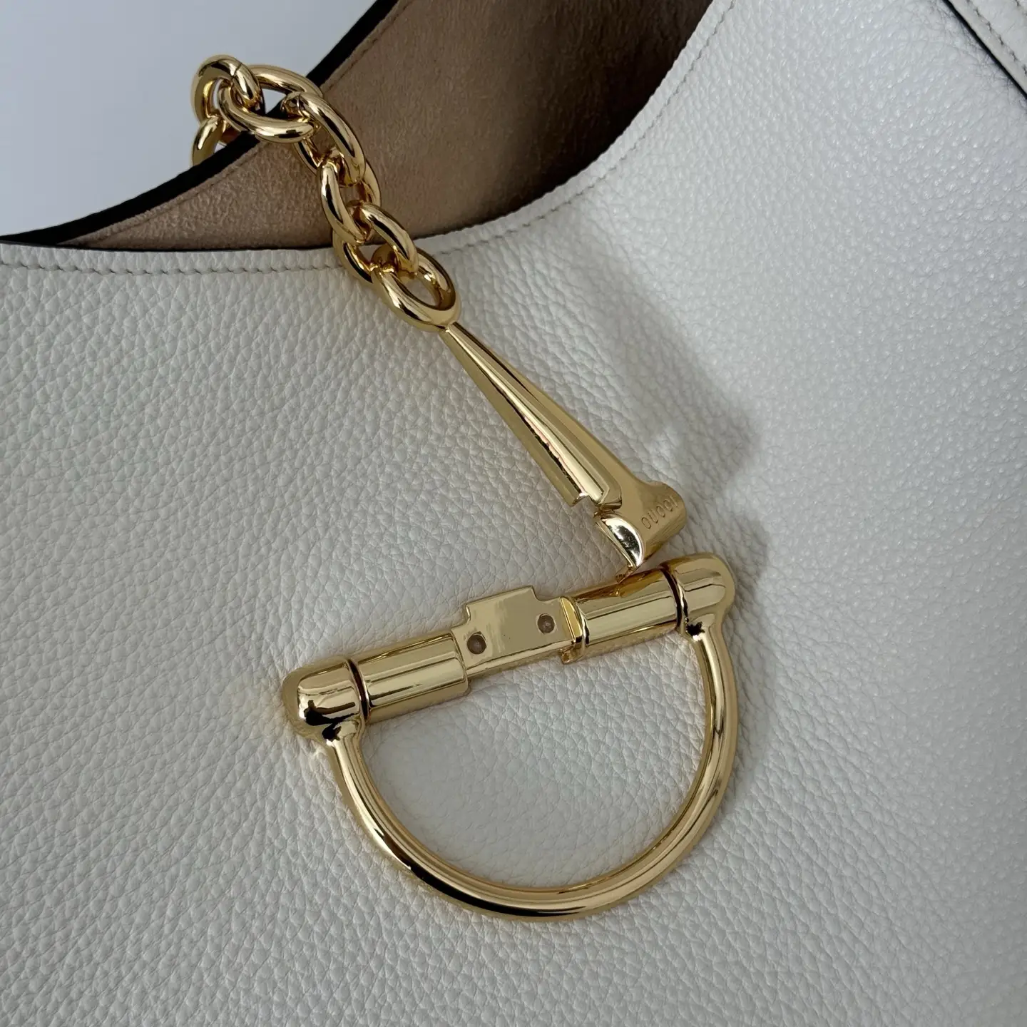 Gucci handbag white pebbled leather gold-tone chain and horsebit hardware close-up