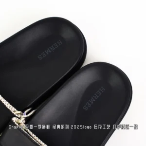 Black Hermes slippers featuring the brand logo, showcasing the Chypre flat design with a classic style, part of the 2025 collection.