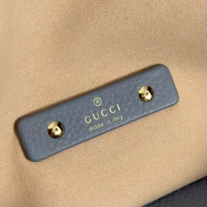 Gucci leather accessory tag gray leather label with gold rivets and embossed logo made in Italy text