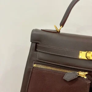 Hermes Kelly Lakis 28 bag in ebony and gold, showcasing the leather texture, gold hardware, and zipper detail.