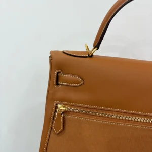 Hermes Kelly Lakis 28 handbag in gold and brown leather with gold buckle and zipper details.