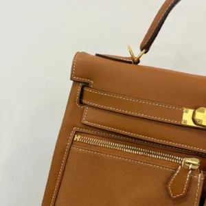Hermes Kelly Lakis 28 handbag in gold and brown leather with gold buckle and zipper details.