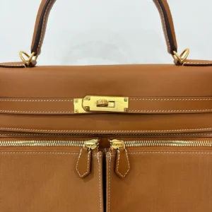 Hermes Kelly Lakis 28 handbag in gold brown leather with gold buckle and zippers, showcasing luxury craftsmanship and design.