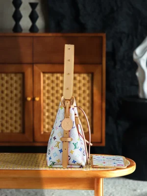 Carryall White Tri Color bag by Louis Vuitton featuring a multicolored monogram design, leather strap, and retro aesthetic, displayed on a wooden table with a stylish background.