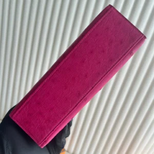 MiniKelly Pocket 22cm East handbag in vibrant magenta leather, showcasing luxurious texture and craftsmanship.