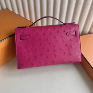 MiniKelly Pocket 22cm East handbag in vibrant pink leather on a neutral background, showcasing luxury craftsmanship and designer style.