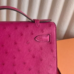 MiniKelly Pocket 22cm East handbag in vibrant pink leather with textured finish, showcasing craftsmanship and luxury design details.