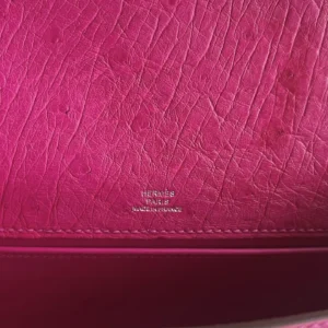 Close-up of the pink leather interior of a MiniKelly Pocket 22cm East handbag, featuring embossed "Hermès Paris" logo and detailed stitching.