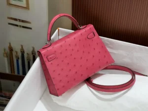 Pink Kelly's second-generation 19CM silver buckle handbag made of ostrich leather, displayed in a white box with a strap alongside.
