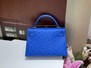 Herm&egrave;s Kelly 25 blue ostrich leather handbag with top handle and polished hardware