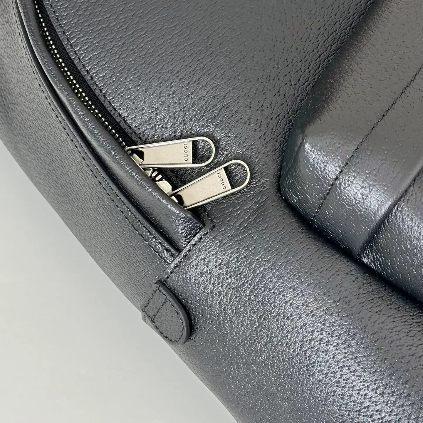Gucci leather bag black leather silver metal dual zipper pulls close-up detail