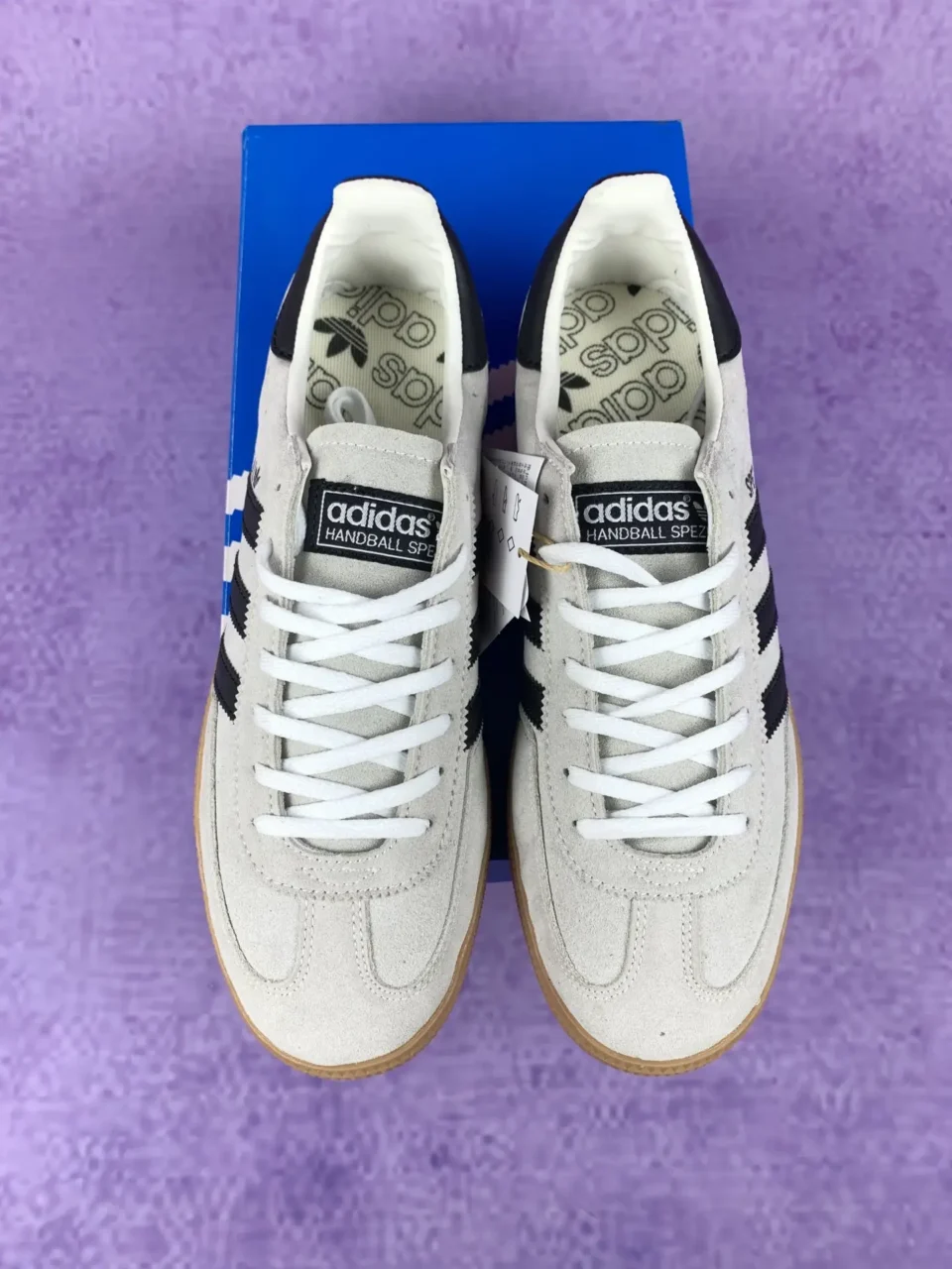 Adidas Handball Spezial white black gum suede sneakers on blue box purple background