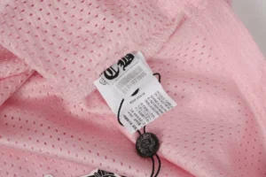 Chrome Hearts mesh pink fabric with care label and black button accessory detail